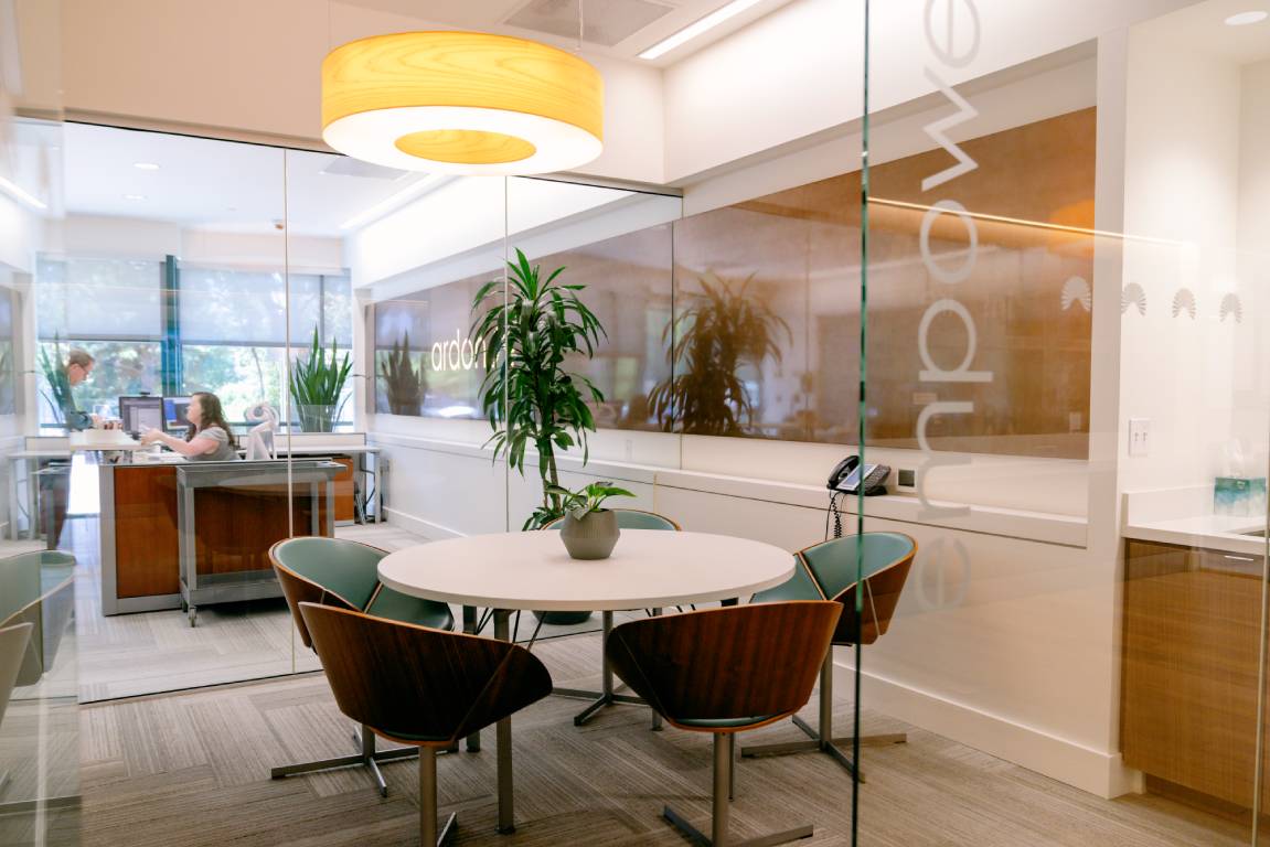 Modern office with round table, glass walls, and festive holiday decor